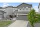 A charming two-story home featuring a two-car garage and a well-maintained lawn with a young tree at 16369 Alberta Dr, Parker, CO 80134