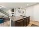 Modern kitchen island featuring a sink, dishwasher, and ample storage space, overlooking the living area at 16369 Alberta Dr, Parker, CO 80134