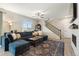 Living room featuring a large sofa, ceiling fan, laminate floors, and staircase at 16369 Alberta Dr, Parker, CO 80134