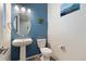 View of the powder room with blue paint and wood-look laminate flooring at 16369 Alberta Dr, Parker, CO 80134