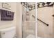Bathroom showcasing a tiled shower with glass door and grab bar, along with a neutral color scheme at 6792 E Briarwood Dr, Centennial, CO 80112