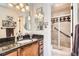 Bathroom featuring granite vanity, modern lighting, and a tiled walk-in shower with glass door at 6792 E Briarwood Dr, Centennial, CO 80112
