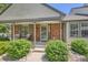 Charming brick home featuring a cozy front porch with inviting seating and a decorative floral wreath on the front door at 6792 E Briarwood Dr, Centennial, CO 80112