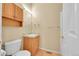 Bathroom with a single sink vanity, oak cabinet, toilet, and updated fixtures at 7870 Sunflower Green # 151, Frederick, CO 80530