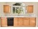 Kitchen featuring wood cabinets, marble countertops, and a view of the landscaped exterior at 7870 Sunflower Green # 151, Frederick, CO 80530