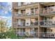 Stacked balconies with white railings, featuring various seating arrangements and potted plants, decorate the exterior at 4801 E 9Th Ave # 209S, Denver, CO 80220