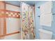Bathroom showing a tub with orange and white tiles and floral curtain, with a light blue wall at 4801 E 9Th Ave # 209S, Denver, CO 80220