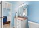 Bathroom with a white vanity and a mirror above the sink, next to the open door looking into the bedroom at 4801 E 9Th Ave # 209S, Denver, CO 80220