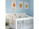 A close-up of a white crib with hanging animal mobiles, perfect for a charming and playful Bedroom at 4801 E 9Th Ave # 209S, Denver, CO 80220