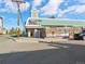 Street view of College Inn building, featuring a clock tower, outdoor seating, and ample parking at 4801 E 9Th Ave # 209S, Denver, CO 80220