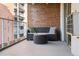 Outdoor patio showing a loveseat with table and surrounding brick walls, perfect for relaxation at 4801 E 9Th Ave # 209S, Denver, CO 80220