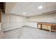 Unfinished basement with painted concrete floor, pegboard walls, and tons of cabinet storage space at 100 Dudley St, Lakewood, CO 80226