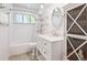 Bright and updated bathroom featuring a white vanity, modern fixtures, and a tub/shower combo at 100 Dudley St, Lakewood, CO 80226