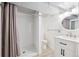 Clean bathroom featuring a tile floor, shower with curtain, single sink vanity with white cabinets and an oval mirror at 100 Dudley St, Lakewood, CO 80226