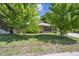 Charming brick home featuring a lush green lawn and mature trees enhancing its curb appeal at 100 Dudley St, Lakewood, CO 80226