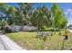 Lawn featuring decorative driftwood art near wooden fence and mature trees at 100 Dudley St, Lakewood, CO 80226