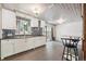 Bright eat-in kitchen features white cabinets, mosaic backsplash, and access to outdoor space at 100 Dudley St, Lakewood, CO 80226