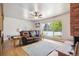 Cozy living room featuring hardwood floors, brick fireplace, and large windows offering bright natural light at 100 Dudley St, Lakewood, CO 80226