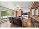 Bright living room boasts hardwood floors, brick fireplace, and large windows offering bright natural light at 100 Dudley St, Lakewood, CO 80226