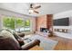 Bright living room boasts hardwood floors, brick fireplace, and a large window providing natural light at 100 Dudley St, Lakewood, CO 80226