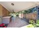 Covered back patio with a hexagon tile floor, serving area, ceiling fans, and a view of the fenced yard at 100 Dudley St, Lakewood, CO 80226