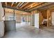 Unfinished basement with exposed beams, concrete floor, and sliding glass door to the backyard at 22527 E Layton Cir, Aurora, CO 80015