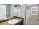 Bathroom featuring a sink, vanity, mirror, neutral walls, and a view into an adjacent bedroom at 22527 E Layton Cir, Aurora, CO 80015