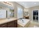 Bright bathroom featuring double sinks, tile flooring, a soaking tub, and a separate glass shower at 22527 E Layton Cir, Aurora, CO 80015
