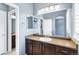 Bathroom featuring wood cabinets, a large mirror, white tiling, and access to a second sink and toilet at 22527 E Layton Cir, Aurora, CO 80015