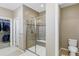 Bathroom shows glass shower, toilet, and access to a walk-in closet with custom organization at 22527 E Layton Cir, Aurora, CO 80015