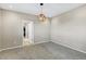 Empty bedroom shows walk-in closet, neutral walls, carpet flooring, and modern geometric light fixture at 22527 E Layton Cir, Aurora, CO 80015