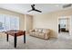 Bonus room featuring a foosball table, a neutral-colored couch, and windows with plantation shutters at 22527 E Layton Cir, Aurora, CO 80015