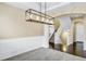 Inviting entryway featuring hardwood floors, carpeted stairs, decorative molding, and an eye-catching modern chandelier at 22527 E Layton Cir, Aurora, CO 80015