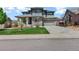 Charming two-story home with manicured lawn, a basketball hoop, and an attached two car garage at 22527 E Layton Cir, Aurora, CO 80015