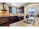Gourmet kitchen featuring dark wood cabinets, stainless steel appliances, and granite countertops at 22527 E Layton Cir, Aurora, CO 80015
