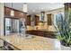 Stylish kitchen boasts stainless appliances, dark wood cabinets, granite countertops and large center island at 22527 E Layton Cir, Aurora, CO 80015