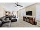 Bright living room with a view of the kitchen and dining area, featuring a black ceiling fan and plantation shutters at 22527 E Layton Cir, Aurora, CO 80015
