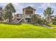 Beautiful backyard with a manicured lawn, mature trees, stone accents, and a two-story home at 5149 Raintree Dr, Parker, CO 80134