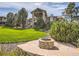 Backyard view featuring a stone fire pit, manicured lawn, lush shrubbery, and a two-story home at 5149 Raintree Dr, Parker, CO 80134