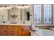 Bathroom with marble countertops, undermount sink, decorative windows, and lovely wooden cabinetry at 5149 Raintree Dr, Parker, CO 80134