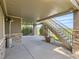 A covered patio featuring stone support beams, a metal staircase, and views of the landscaped yard at 5149 Raintree Dr, Parker, CO 80134