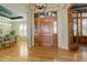 Grand foyer with wooden door, hardwood floors, statement lighting, and views of dining area at 5149 Raintree Dr, Parker, CO 80134