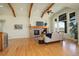 Open-concept living room featuring hardwood floors, wood beams, and large windows showcasing picturesque views at 5149 Raintree Dr, Parker, CO 80134
