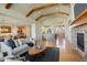 Bright and spacious living room with a stone fireplace, hardwood floors, and an open layout leading to the kitchen at 5149 Raintree Dr, Parker, CO 80134