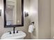 Modern powder room with a pedestal sink, black fixtures and neutral walls at 5149 Raintree Dr, Parker, CO 80134