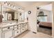 Bathroom featuring dual sinks, granite countertops, modern lighting, and decorative flower arrangements at 5133 E Essex Ave, Castle Rock, CO 80104