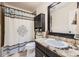 Bathroom with a granite vanity, shower, decorative mirror, and dark wood accents at 5133 E Essex Ave, Castle Rock, CO 80104