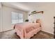 Cozy bedroom with plush carpeting, a pink bedspread, and a window offering natural light at 5133 E Essex Ave, Castle Rock, CO 80104