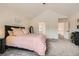Bright bedroom featuring carpet flooring, a black accent table, and a comfortable bed with pink linens at 5133 E Essex Ave, Castle Rock, CO 80104