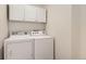 Laundry room featuring a white washer, a white dryer, and storage cabinets at 5133 E Essex Ave, Castle Rock, CO 80104